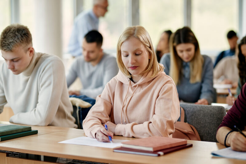 1718568267young woman writing exam in lecture hall at the un 2023 11 27 05 33 28 utc 800x533